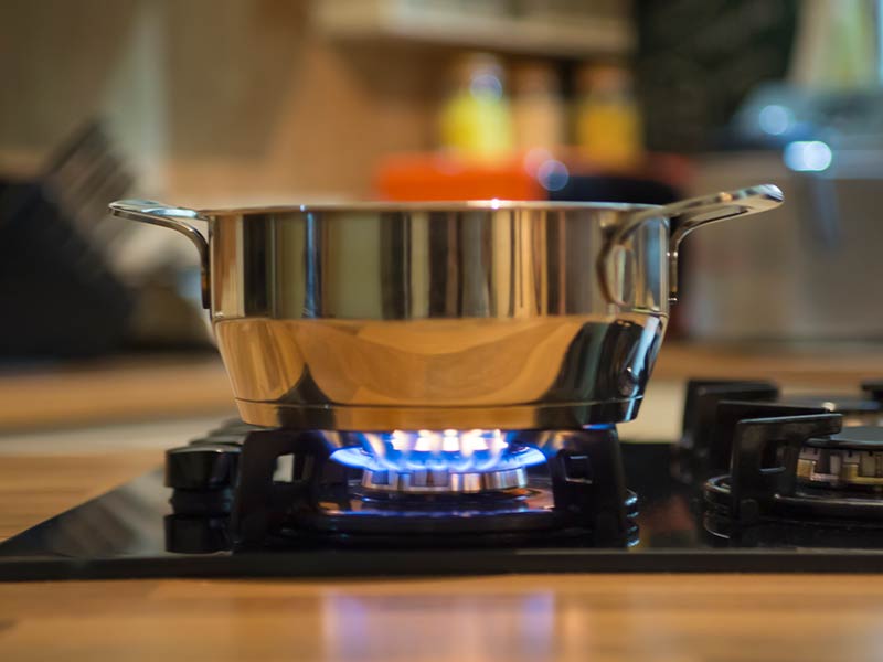 Stainless steel pot on a burner in a gourmet kitchen